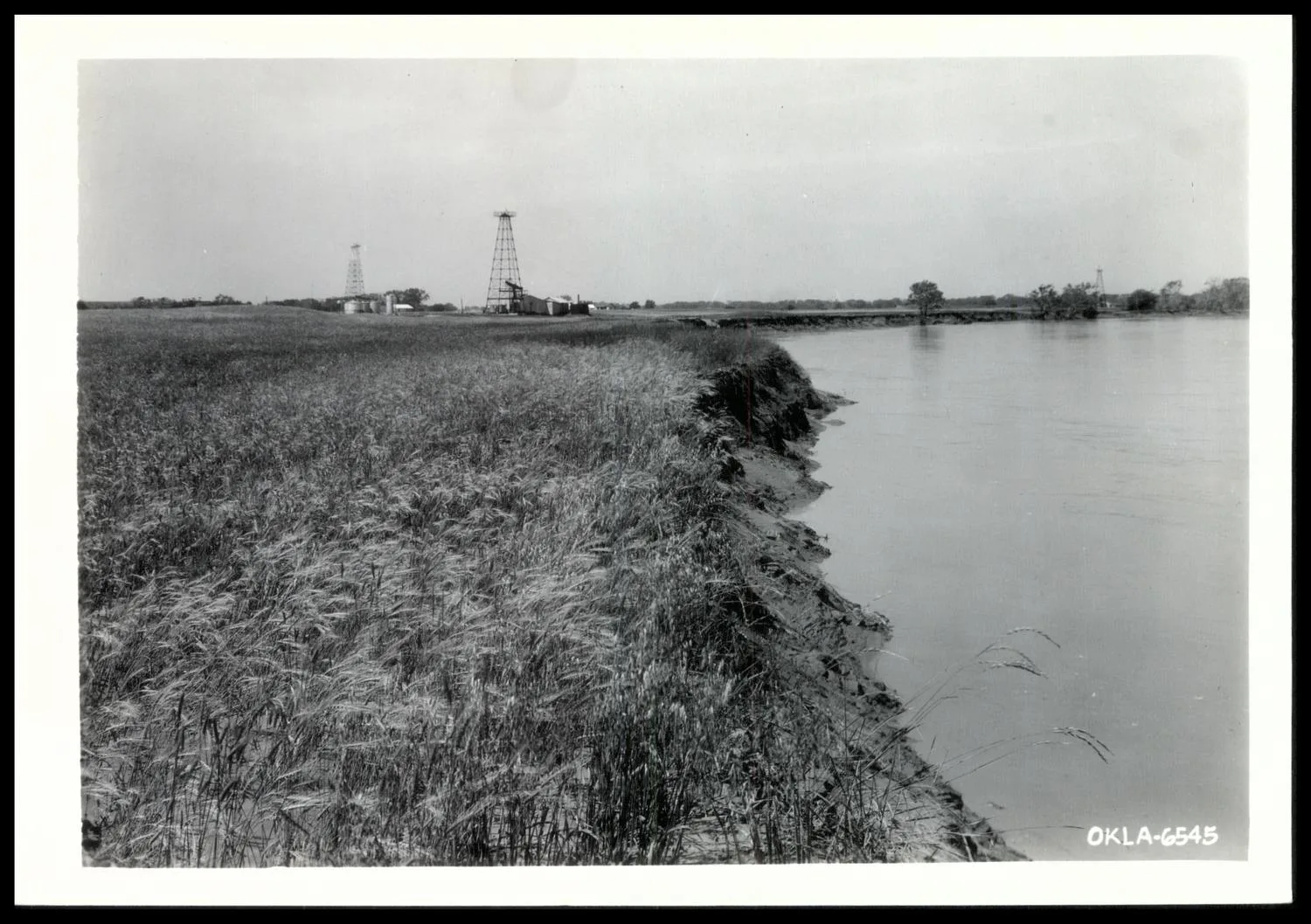 Photograph of field which has sloughed off 20 feet on a half mile band. Beside losing this land forever this farmer also lost 30 acres of wheat in a 50 acre field due to water running over field and silting. Salt Fork River