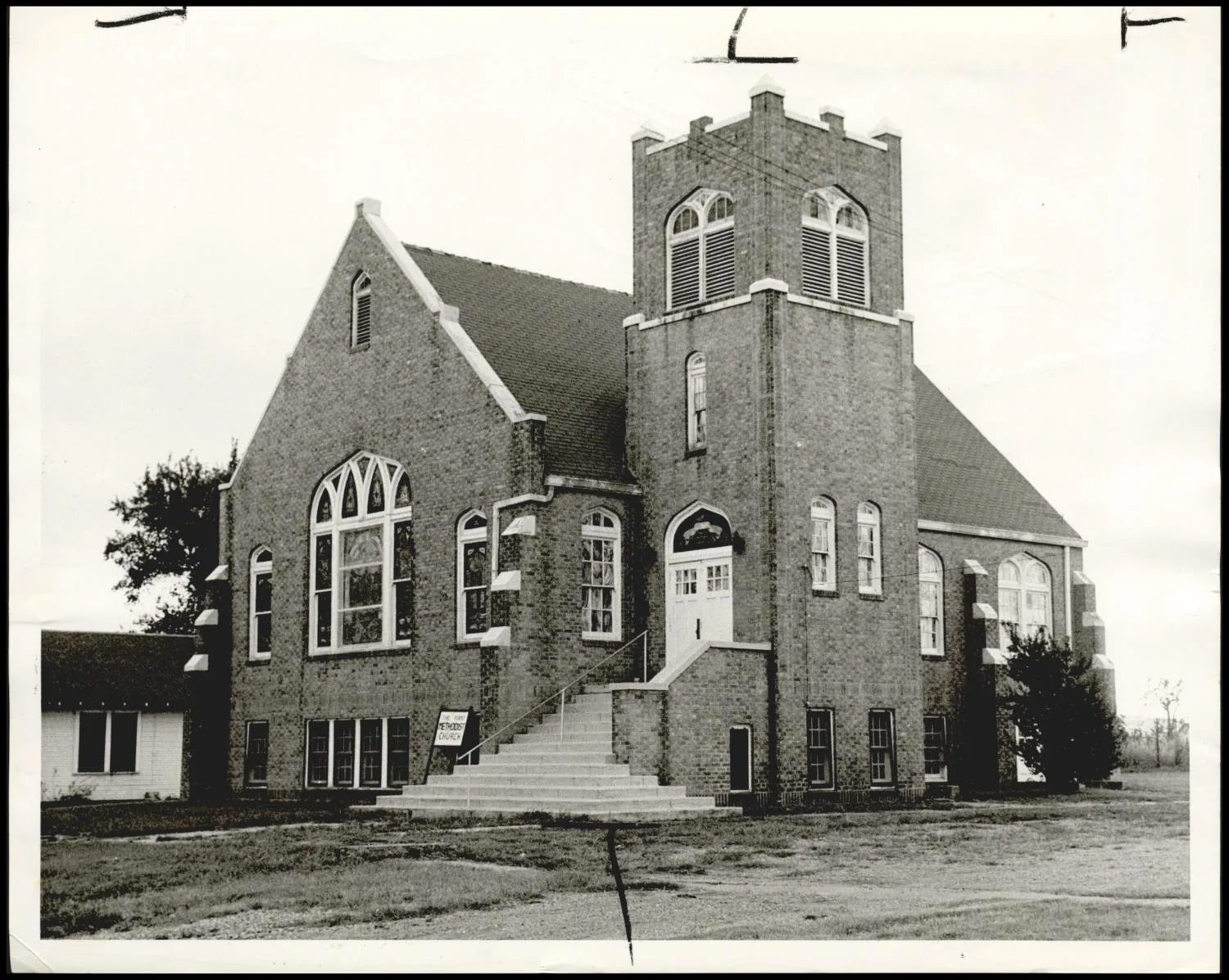 Photograph taken for a story in the Oklahoma Times newspaper. Caption: "Mowing a lawn in front of this church, Earlsboro's most outstanding citizen, L. F. Casteel, was stricken with a heart attack and died August 2. Monday, the town was in shock again, over closing of Casteel's band and a reported shortage of $250,000."