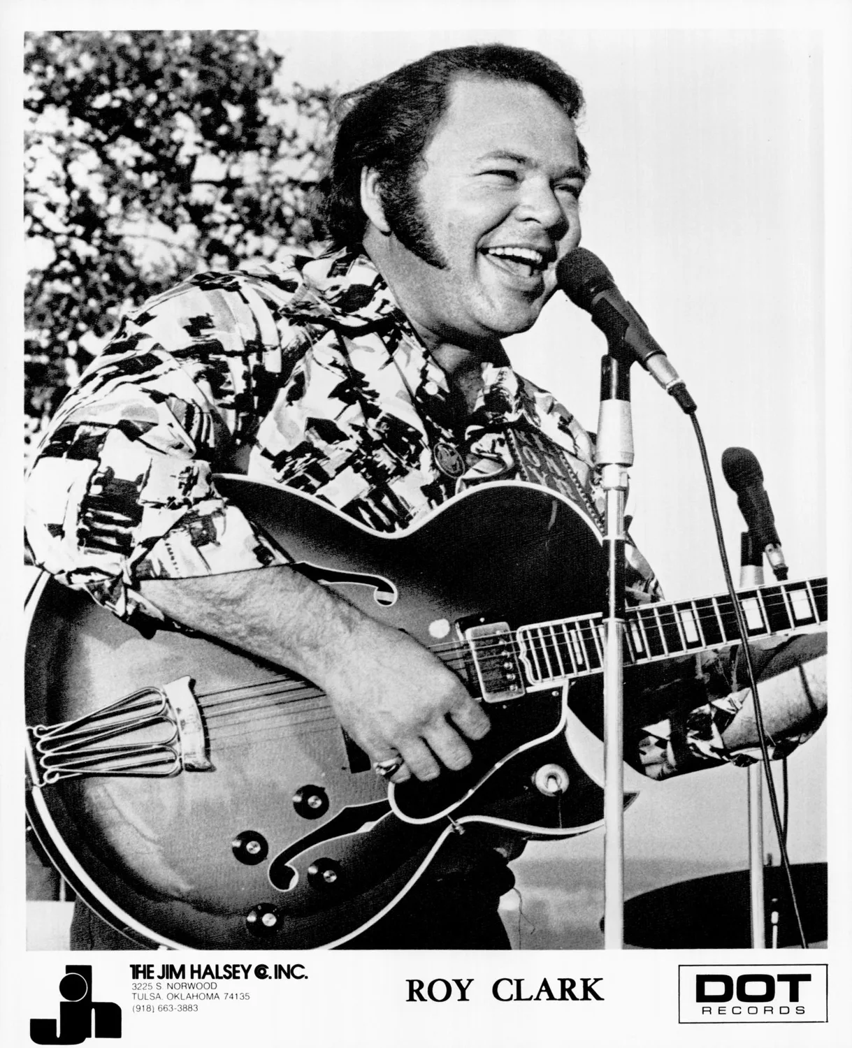 Clark Roy playing guitar in sport shirt.