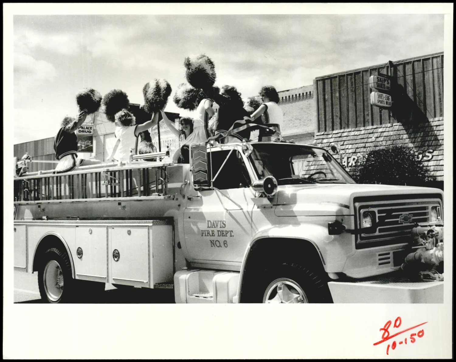 Photograph used for a story in the Daily Oklahoman newspaper. Caption: "Cheerleaders riding on a firetruck illustrate the attitude that has gotten Davis national attention."