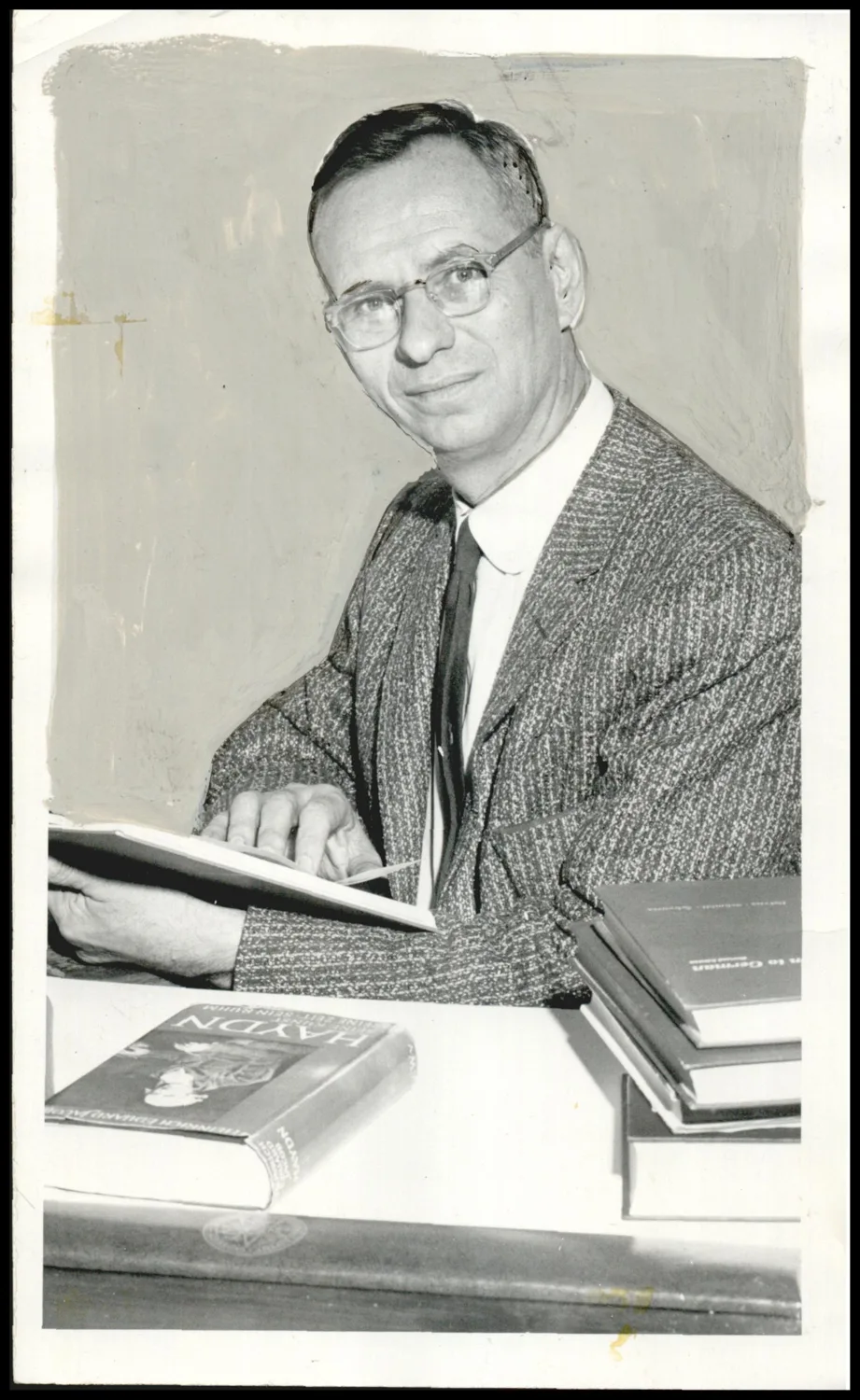 Photograph used for a story in the Oklahoma Times newspaper. Caption: "MANY SIDED. Musician, teacher, linguist, theologian, Dr. Robert O. Laessig, professor of humanities at Oklahoma Baptist university, glances through a music book, one of his many interests."