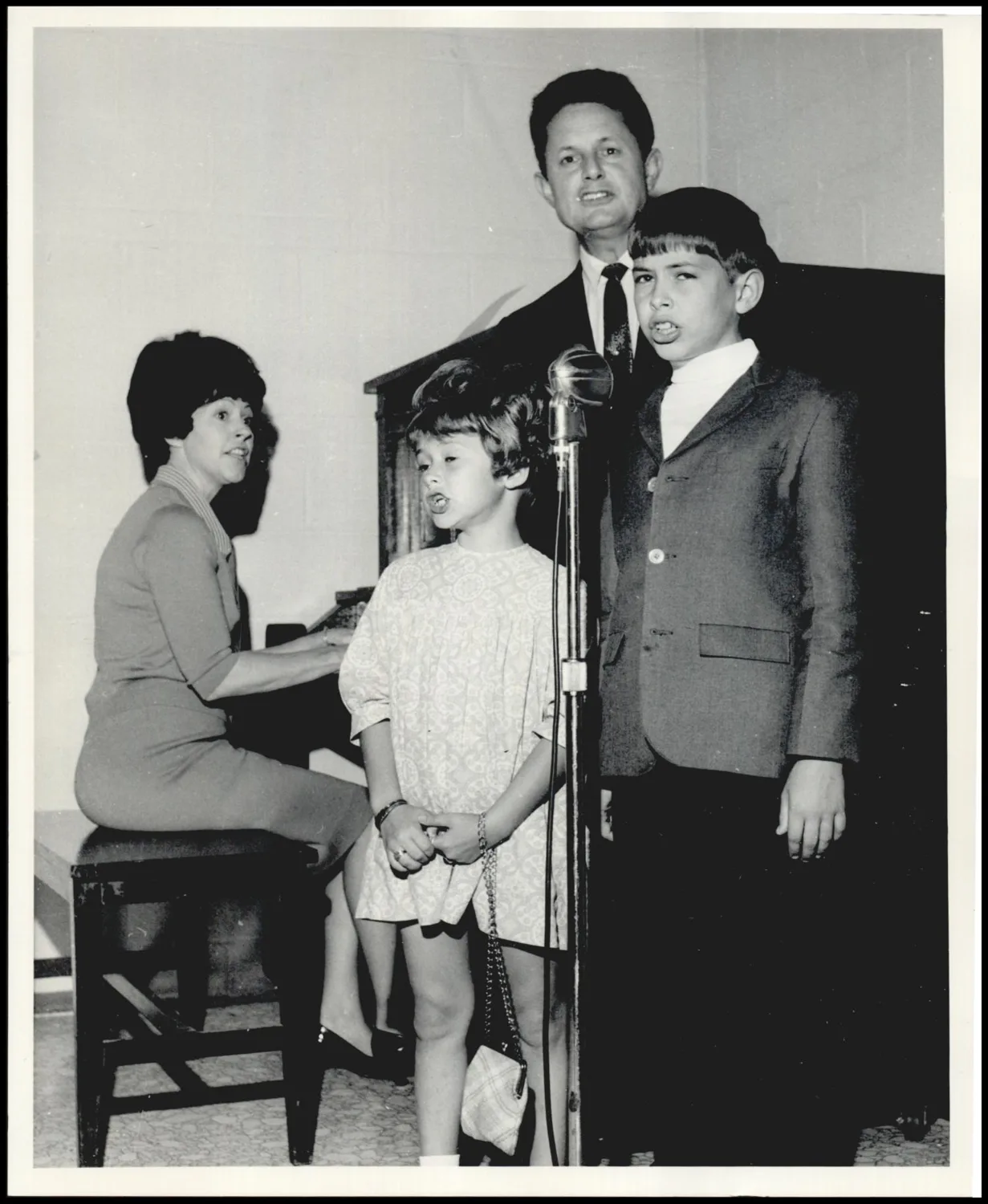 Photograph used for a story in the Daily Oklahoman newspaper. Caption: "Kerleys presenting program - Mrs. Kerley (Joy) at piano. Kerley, Kim and Karla singing with her."