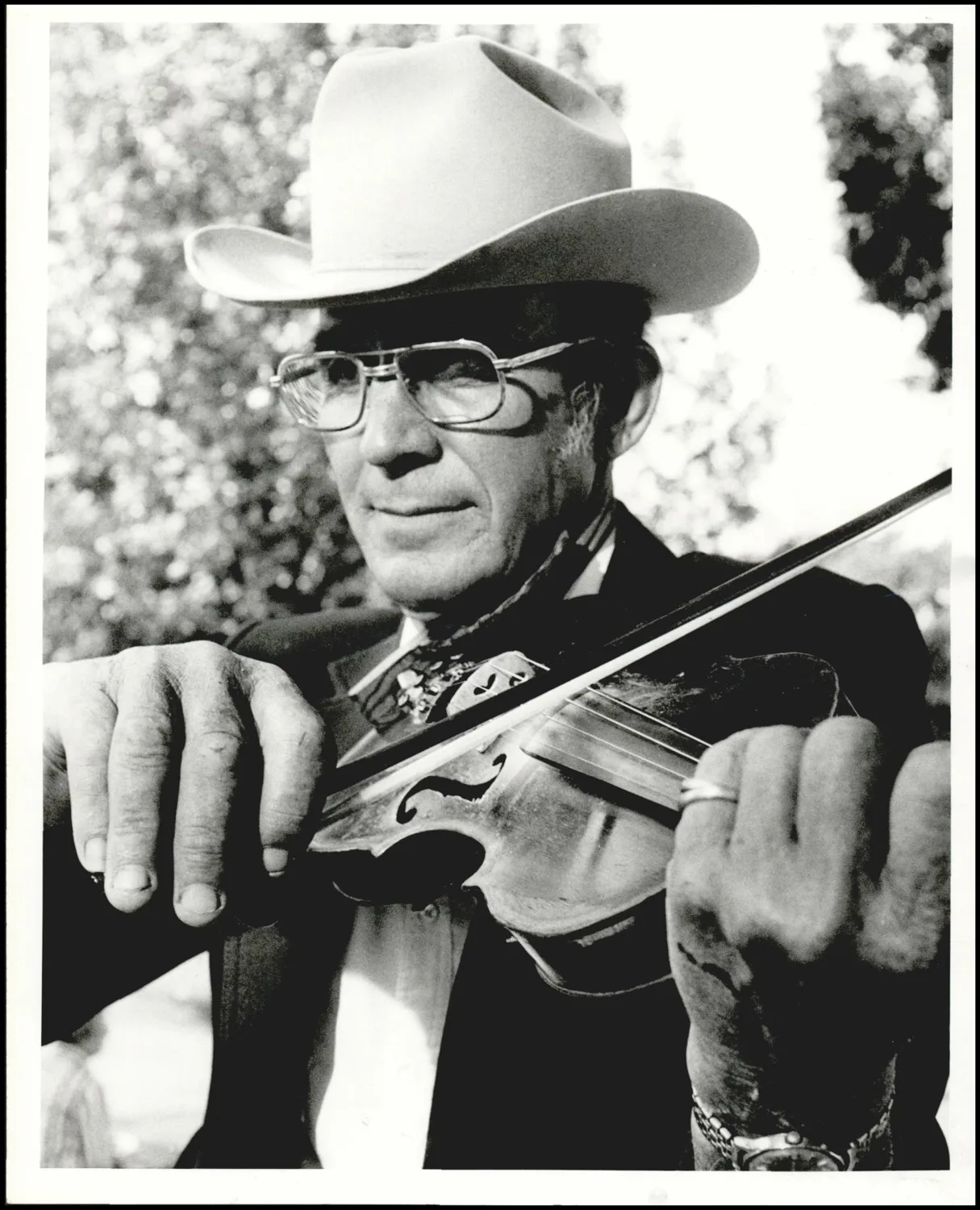 Photograph used for a story in the Daily Oklahoman newspaper. Caption: "Ace Sewell of Blanchard plays his fiddle at the Diamond Jubilee Arts Festival Saturday on the lawn of the state capitol."