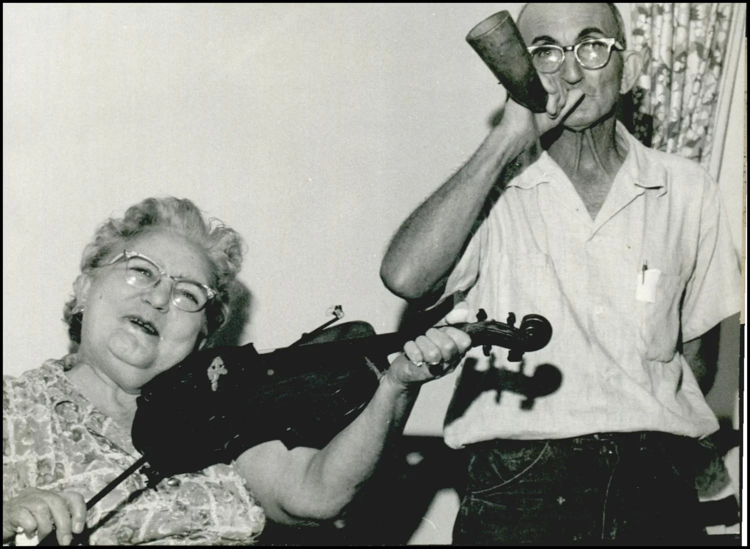 Photograph used for a newspaper owned by the Oklahoma Publishing Company. Caption: "Old Fiddle and an antque fox horn are shown off by Mr. and Mrs. M.B. Rimmer at their home in Duncan."
