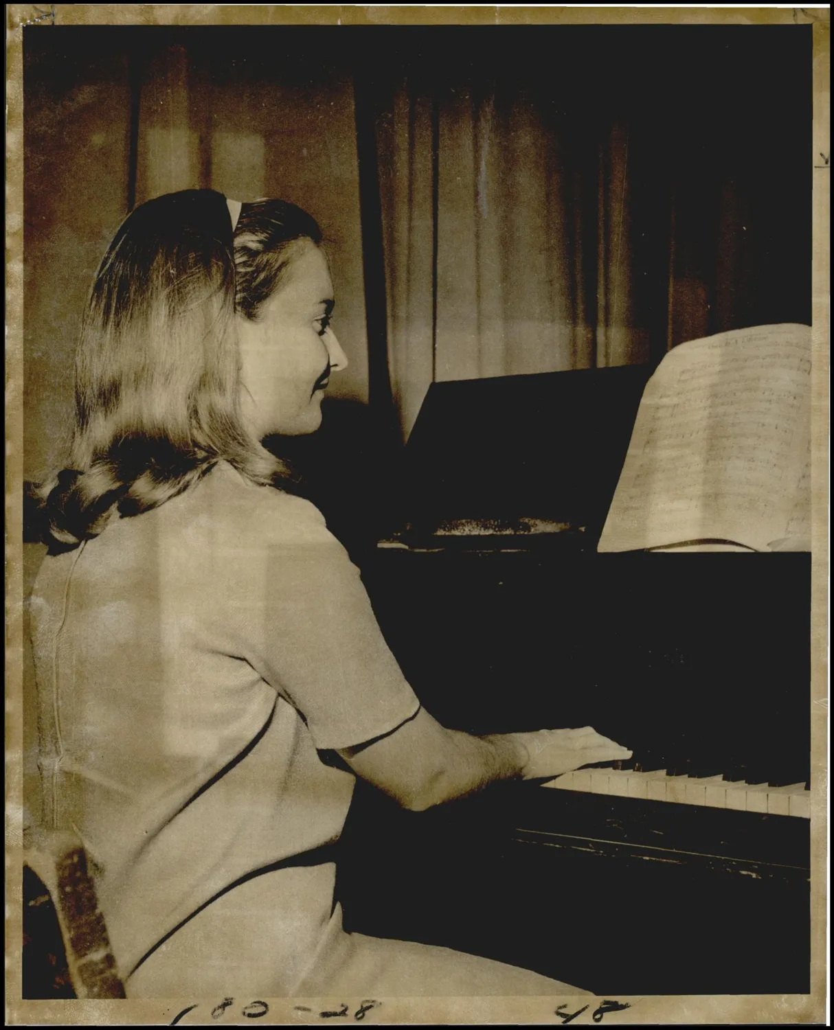 Photograph used for a story in the Oklahoma Times newspaper. Caption: "Playing the piano is just one of the many things Joan Whelchel enjoys doing."